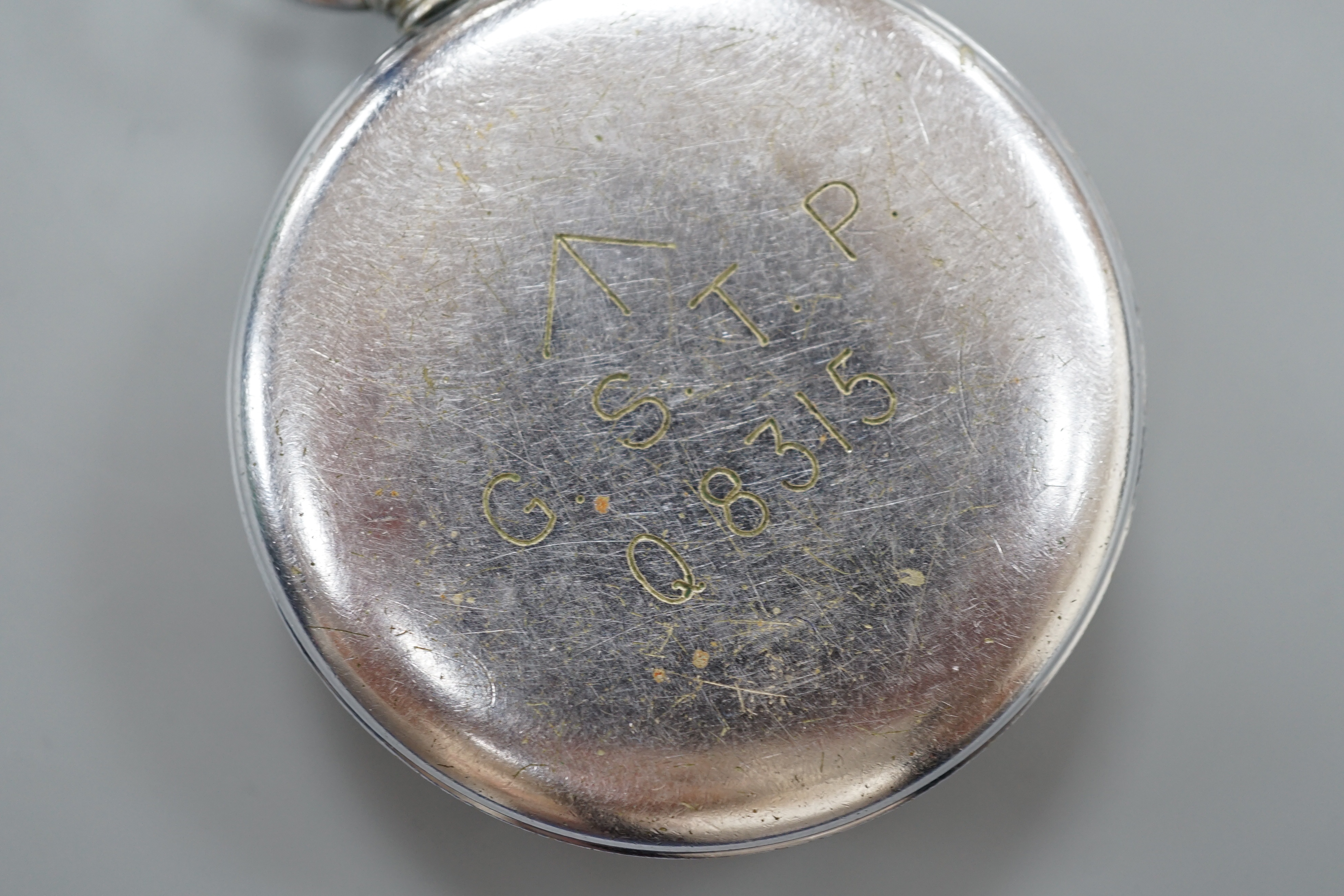 A military issue chrome cased keyless pocket watch, with black Arabic dial and subsidiary seconds, the case back engraved with broad arrow G.S.T.P. over Q 8315.